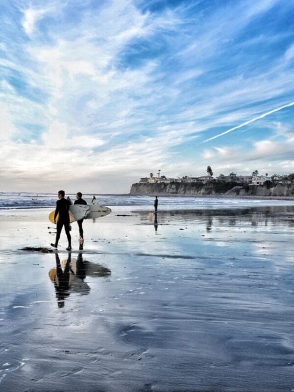 Sunset at the beach of San Diego with surfers